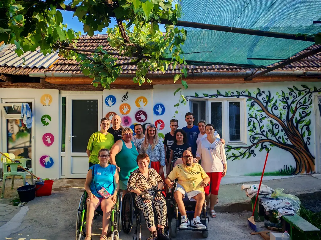 Grup în curtea Căsuței Prieteniei, în fața peretelui pictat