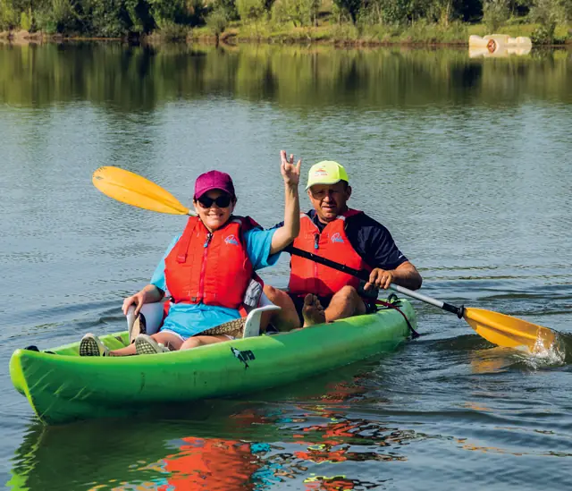 Doi oameni într-un caiac verde, pe lac